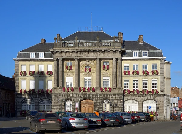 Photographie réaliste d'une rue ou place caractéristique de Condé-sur-l'Escaut, montrant l'architecture locale distinctive de la ville avec des bâtiments ou repères visuels reconnaissables. L'image doit être claire, bien éclairée et de qualité professionnelle, sans texte ni filigrane visible.